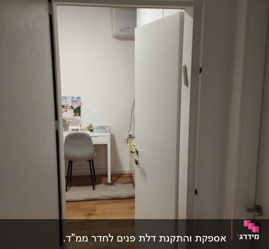 דלת לבנה פתוחה לחדר עם רצפת עץ